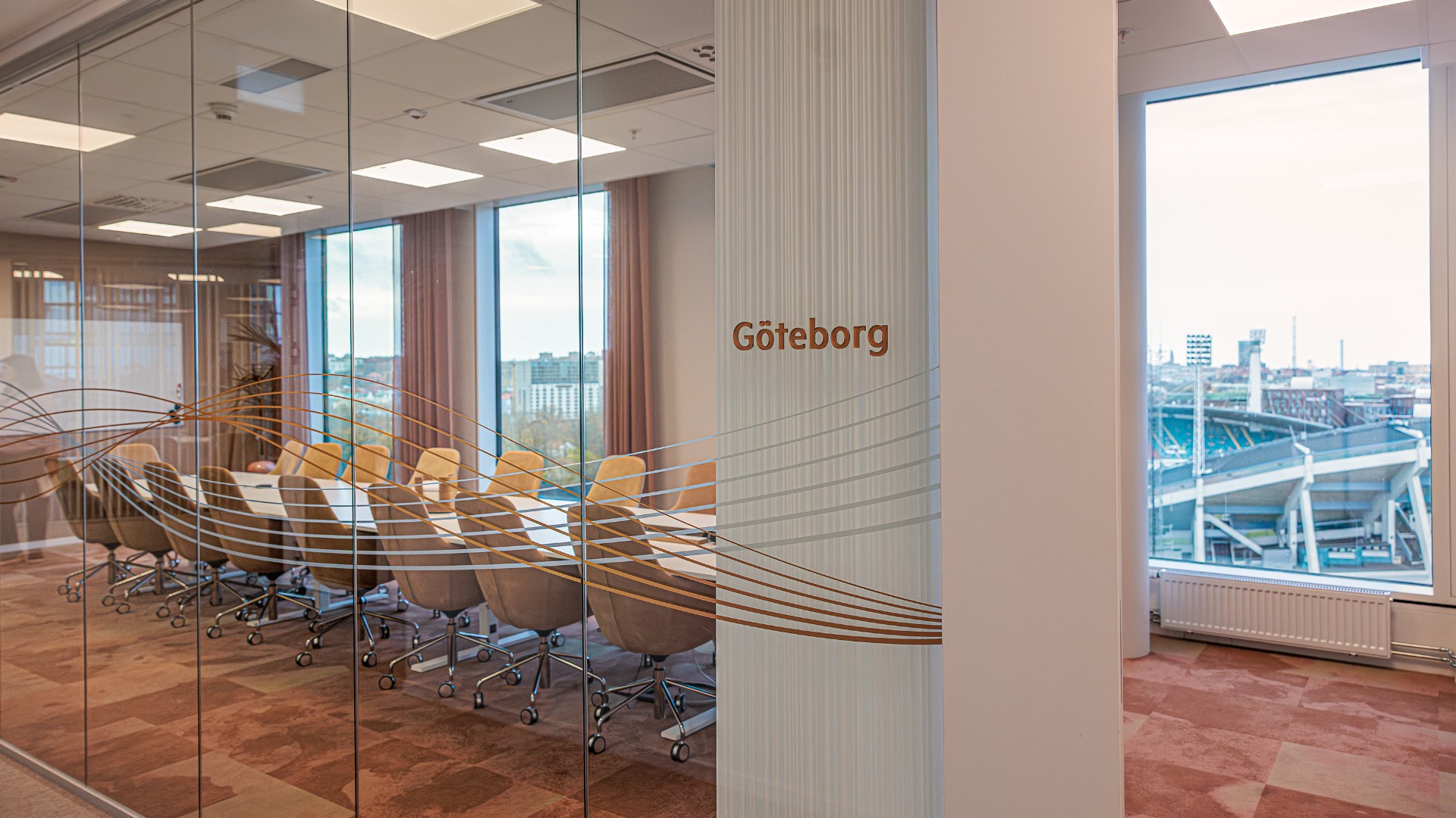 Modern konferensrum med glasväggar och stadsutsikt i Göteborgs kontorslokal.