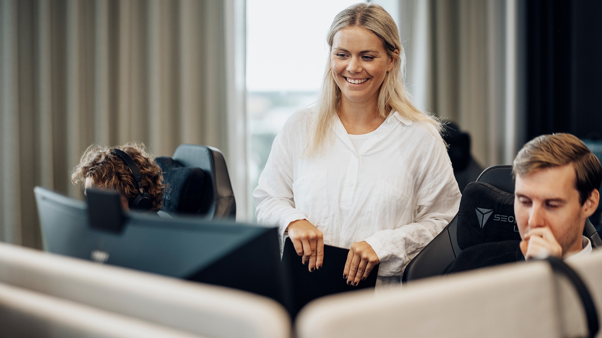 Samarbetsinriktat teamarbete i en modern kontorsmiljö Kontorsmiljö med personer som använder datorer, med modern utrustning och bekväma sittplatser.