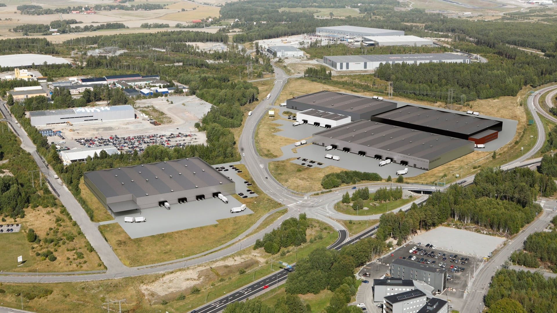 Aerial view of a modern industrial park with multiple warehouses surrounded by greenery.
