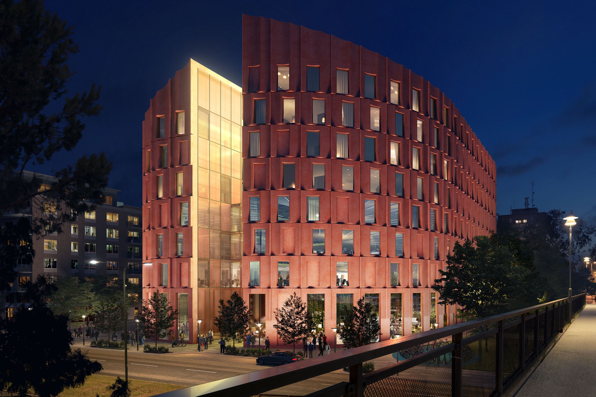 Modern röd byggnad upplyst på natten - Arkitektoniskt underverk Modern flerplansbyggnad med lysande fasad, omgiven av träd, fotograferad i skymningen.