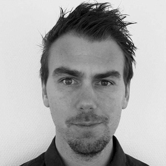 Andreas Haag En person med kort, rufsigt hår och en skjorta med krage mot en enkel vit bakgrund.