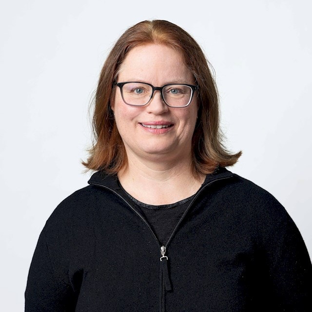 Dagmar Gormsen En person med axellångt brunt hår som bär en svart zip-tröja mot en vit bakgrund.