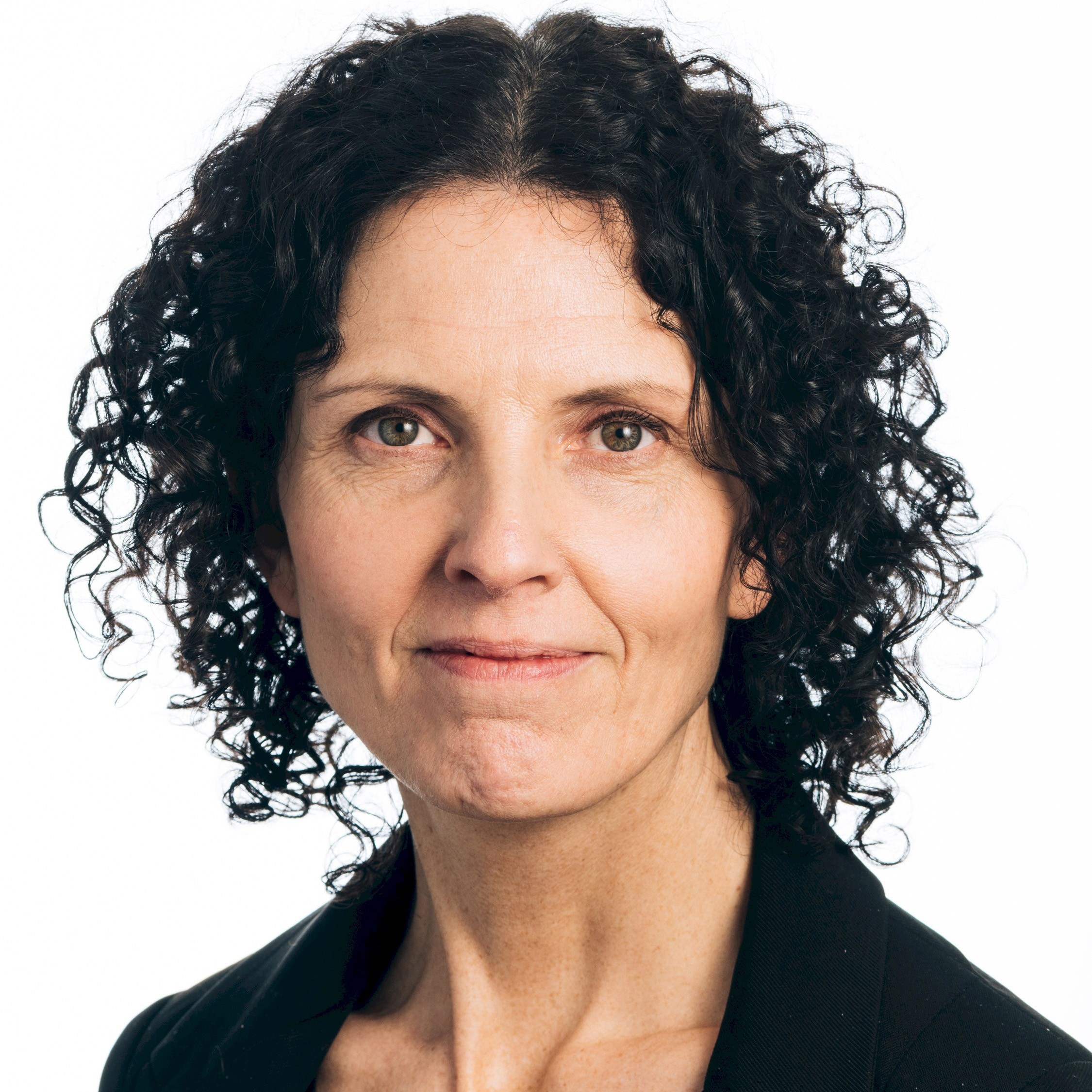 A woman with short dark curly hair.