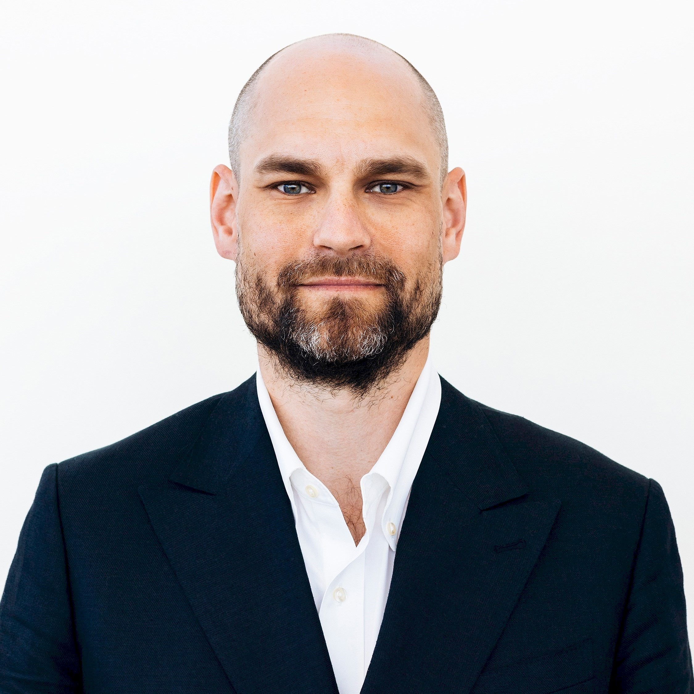 Jacob Birkeland En person i en formell kostym med vit skjorta står mot en enkel vit bakgrund.