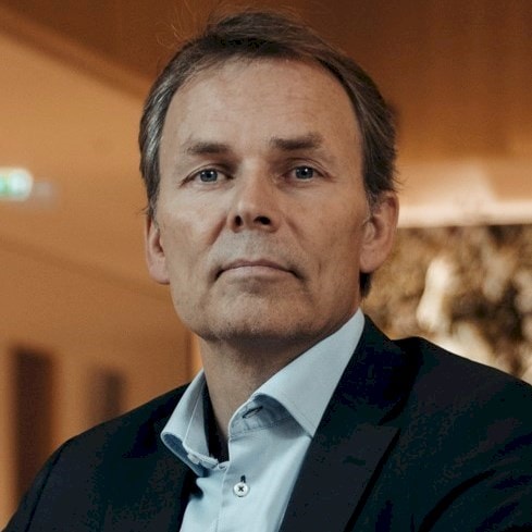 Jan Odelstam Person in a dark blazer and light blue shirt in a professional indoor environment.