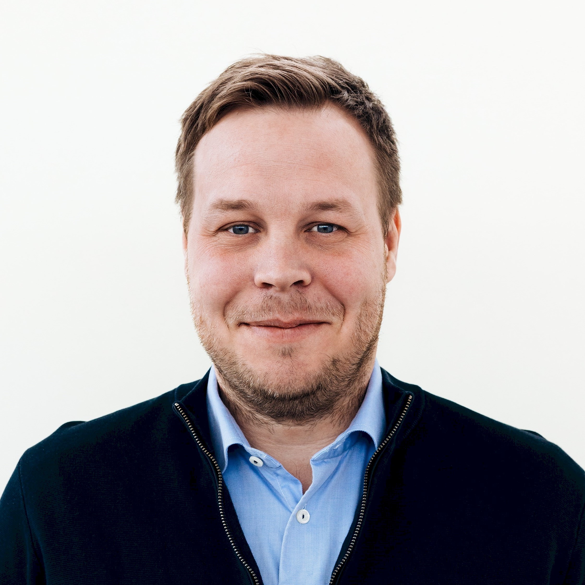 Jesper Toreheim Man in blue shirt and dark jacket against a plain white background.