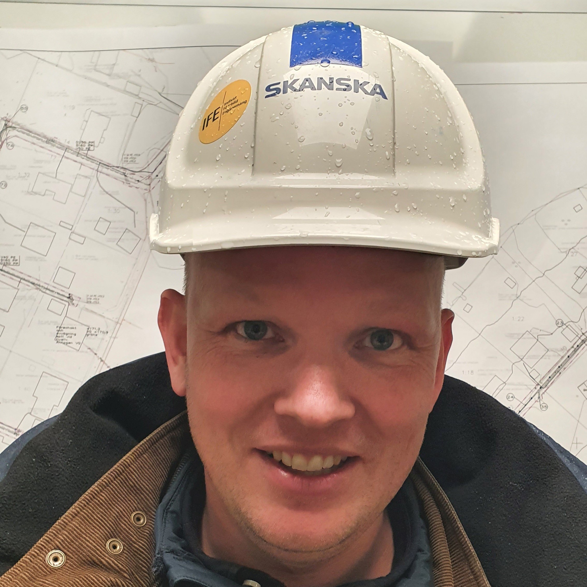 Johannes Gustafsson En man med vid bygghjälm det står Skanska på.