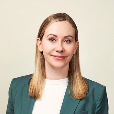 Krista Niemi Person with long blonde hair wearing a teal blazer and white top.