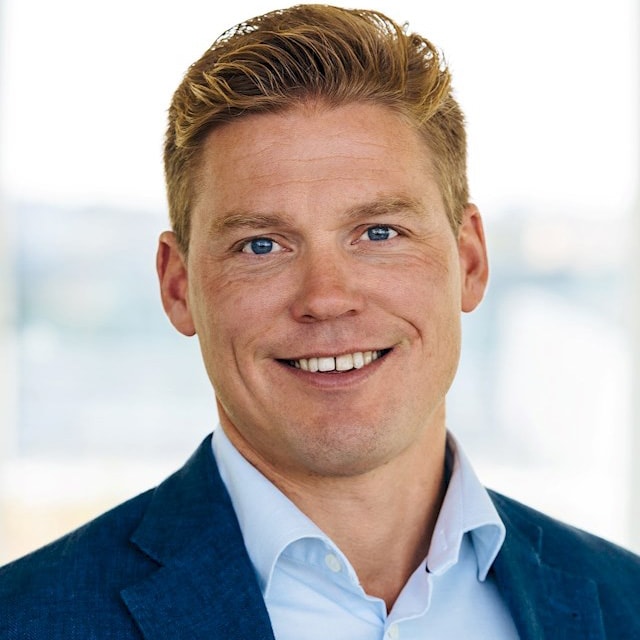 Marcus Gatu Person med blont kortklippt hår i blå kostym och ljusblå skjorta.