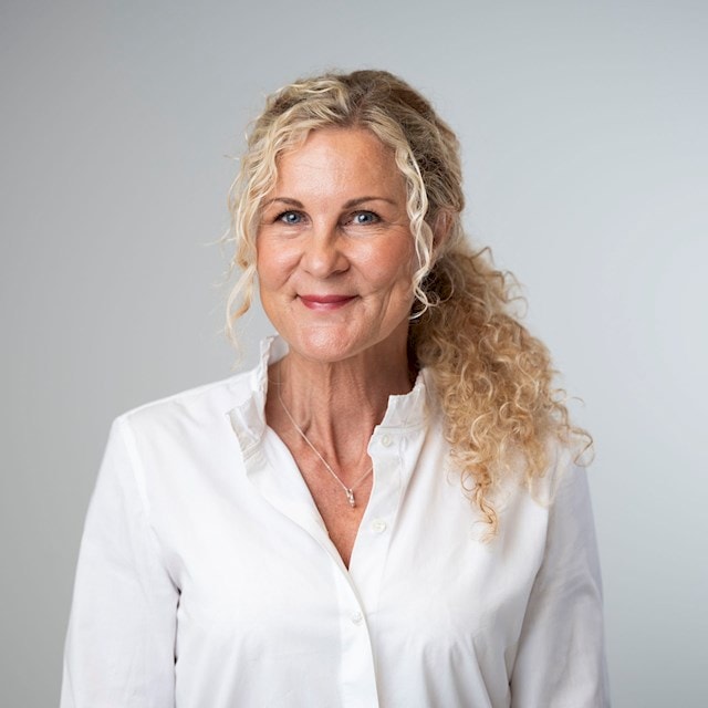 Maria Rydberg Person med lockigt blont hår som bär en vit skjorta med knappar och ett halsband.