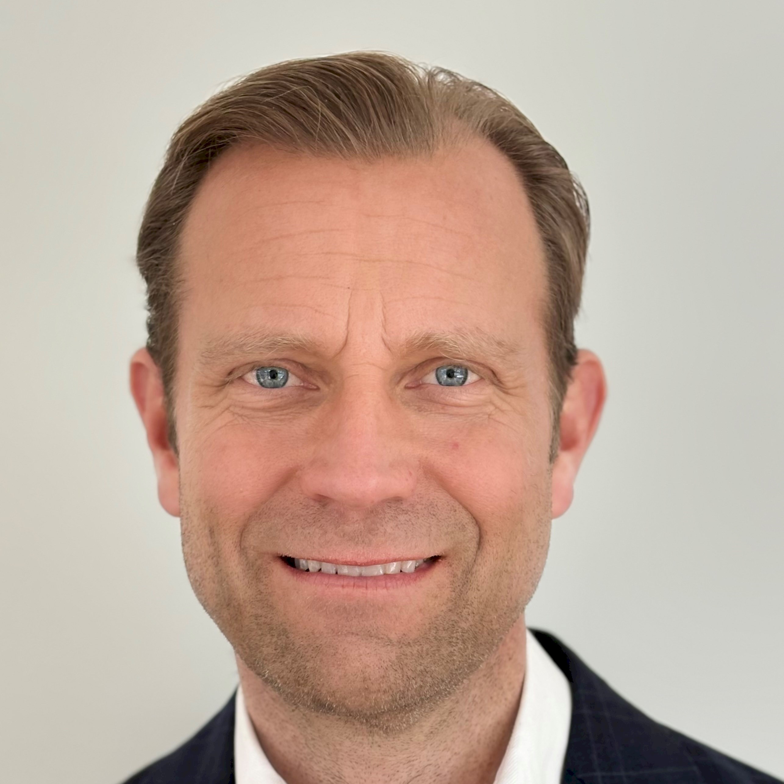Markus Dangré Person med välkammad hår som bär en mörk kavaj och vit skjorta.
