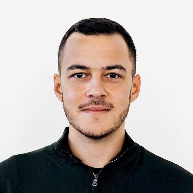 Samir Ezmorrod En person som bär en svart jacka med blixtlås mot en enkel vit bakgrund.