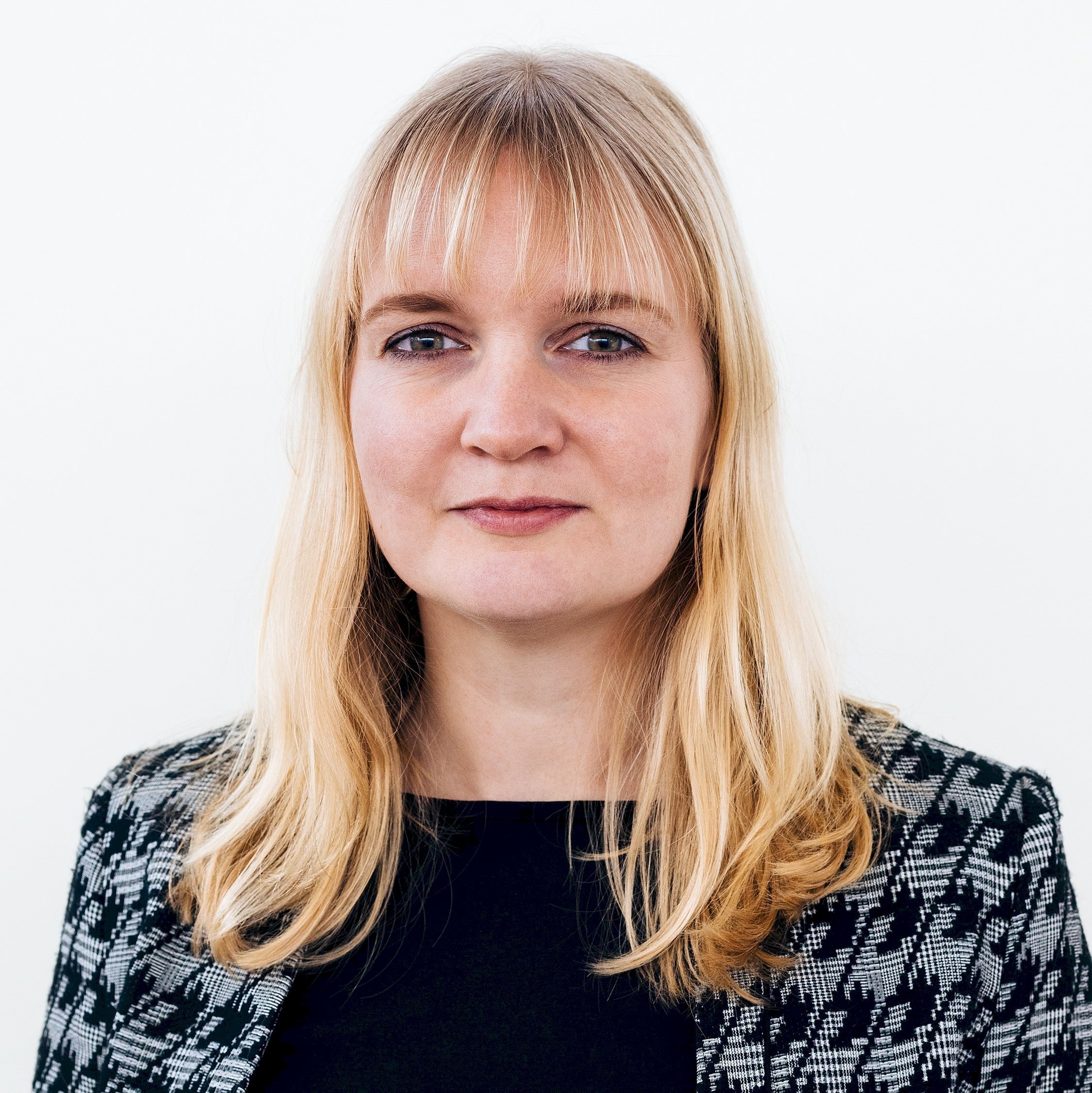 Therese van Gerwen En person med långt blont hår som bär en svartvit mönstrad jacka över en svart topp.