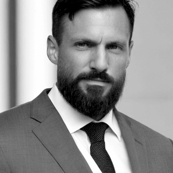 Victor Garcia Öjring A person in a suit and tie stands against a light background and displays professional attire.