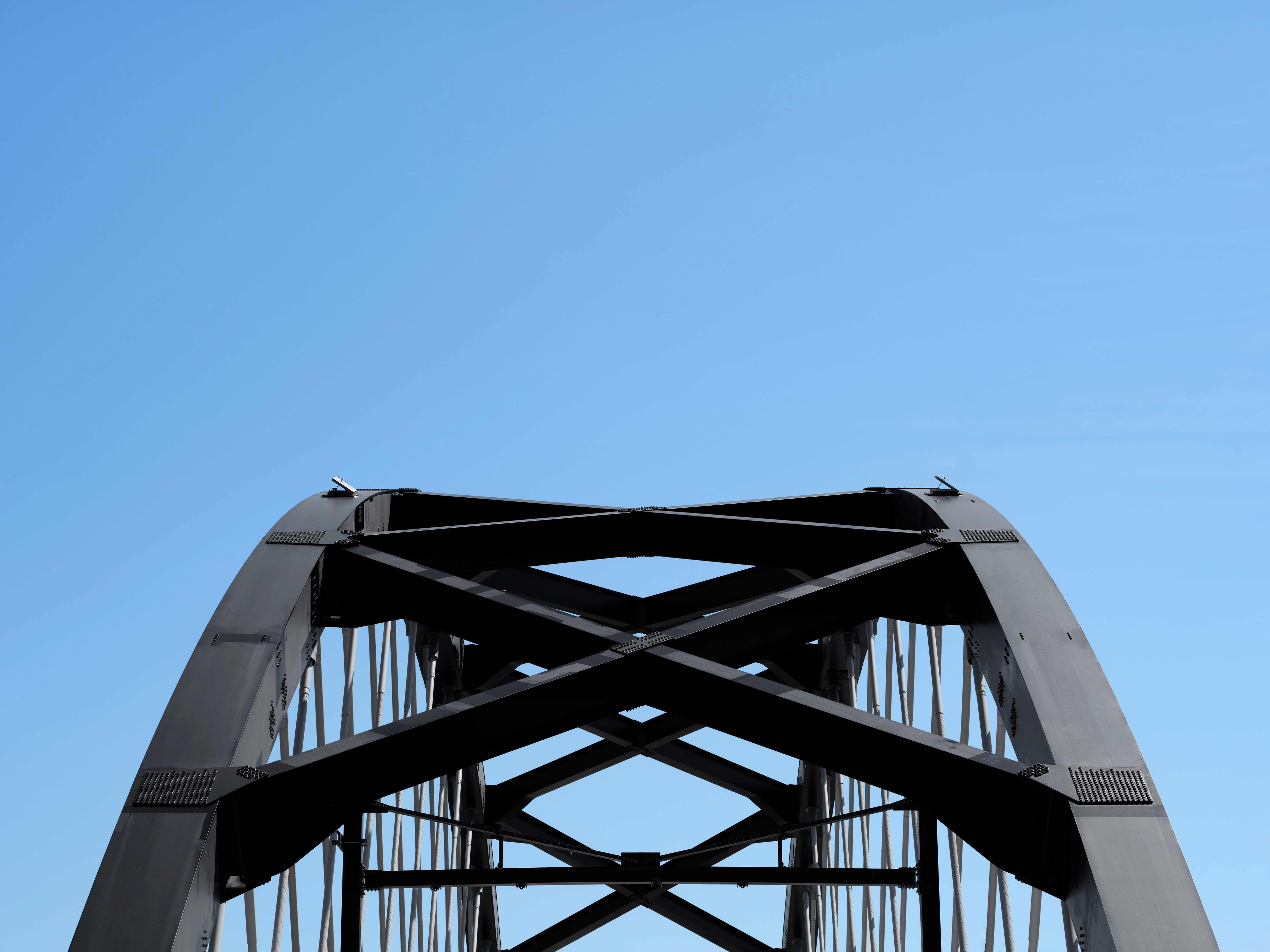Stålbrobåge mot en klarblå himmel, som visar upp arkitektonisk design och ingenjörskonst.