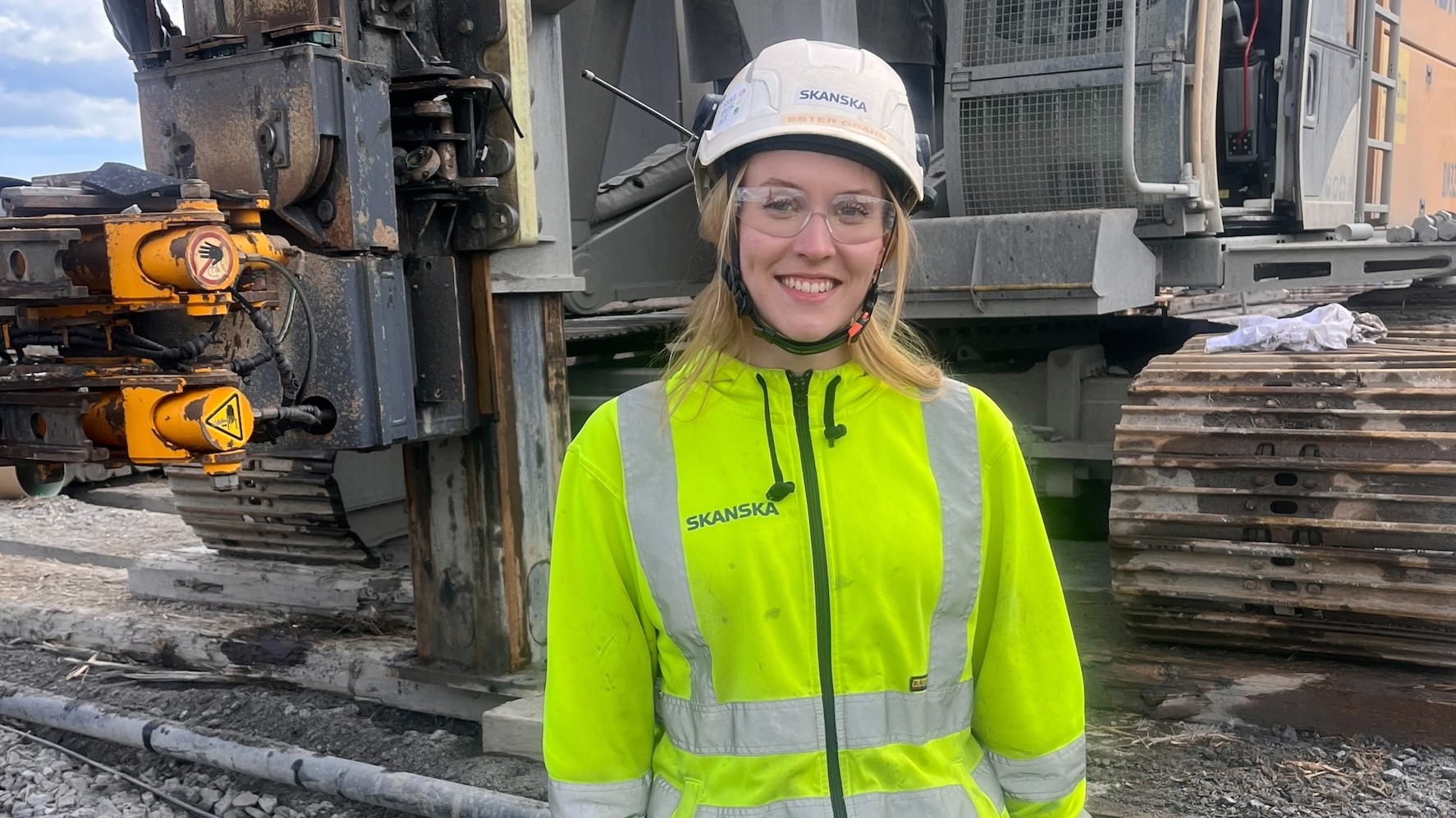 Ester Grahn som är med och lägger grunden till en av Sveriges mest ambitiösa klimatsatsningar. Kvinnlig ingenjör på Skanska står framför en pålningsmaskin.