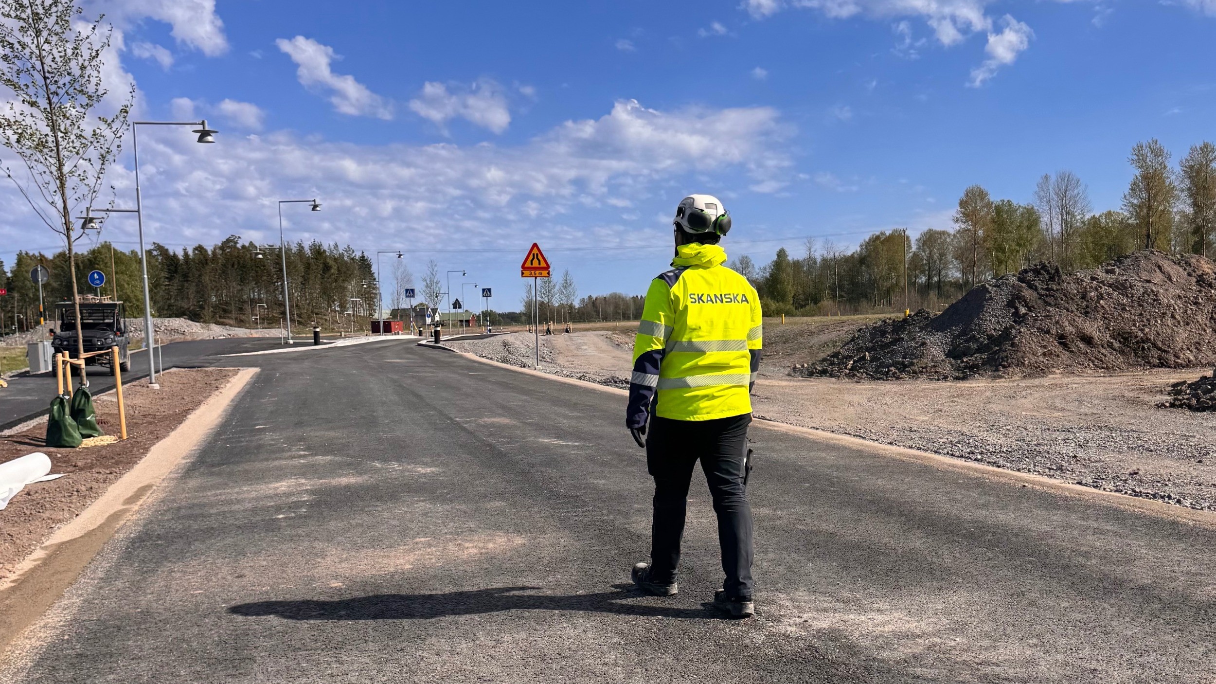 Vägbygge Skanskas produktionsingenjör Halil Uluseker står på en asfalterad väg i Västerhaninge.