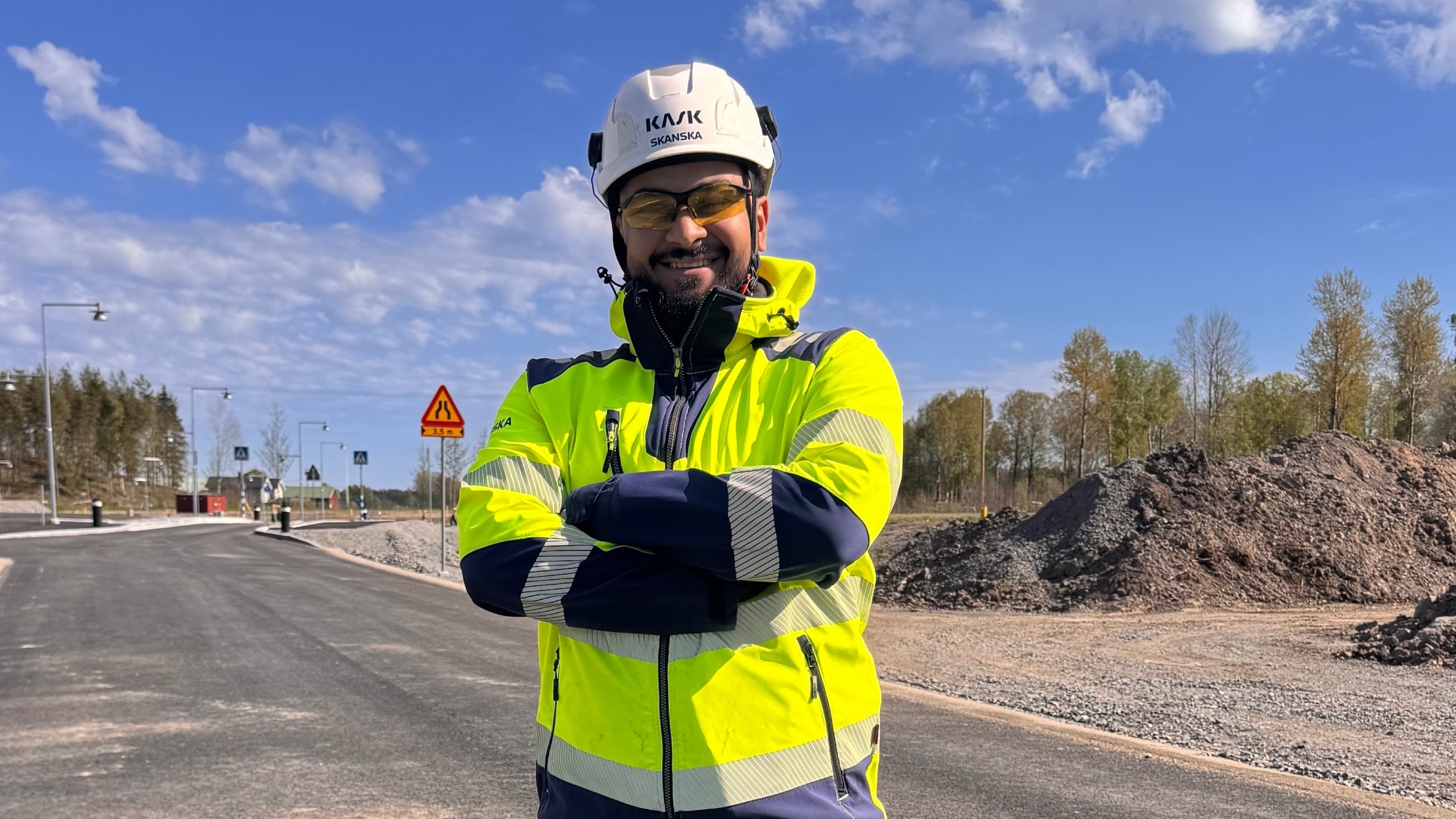 Halil Uluseker Porträtt på Skanskas produktionsingenjör Halil Uluseker i hjälm och gul varseljacka.