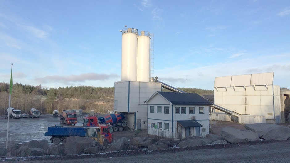 Concrete Plant with Cement Trucks and Silos in Clear Sky Industriell cementfabrik med silos, lastbilar och maskiner under en klar himmel.