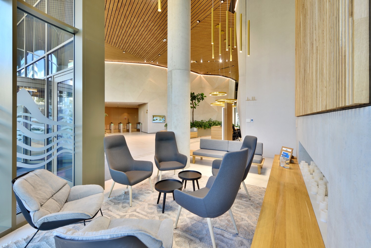Modern office lobby with stylish seating, wooden accents, and elegant pendant lighting.