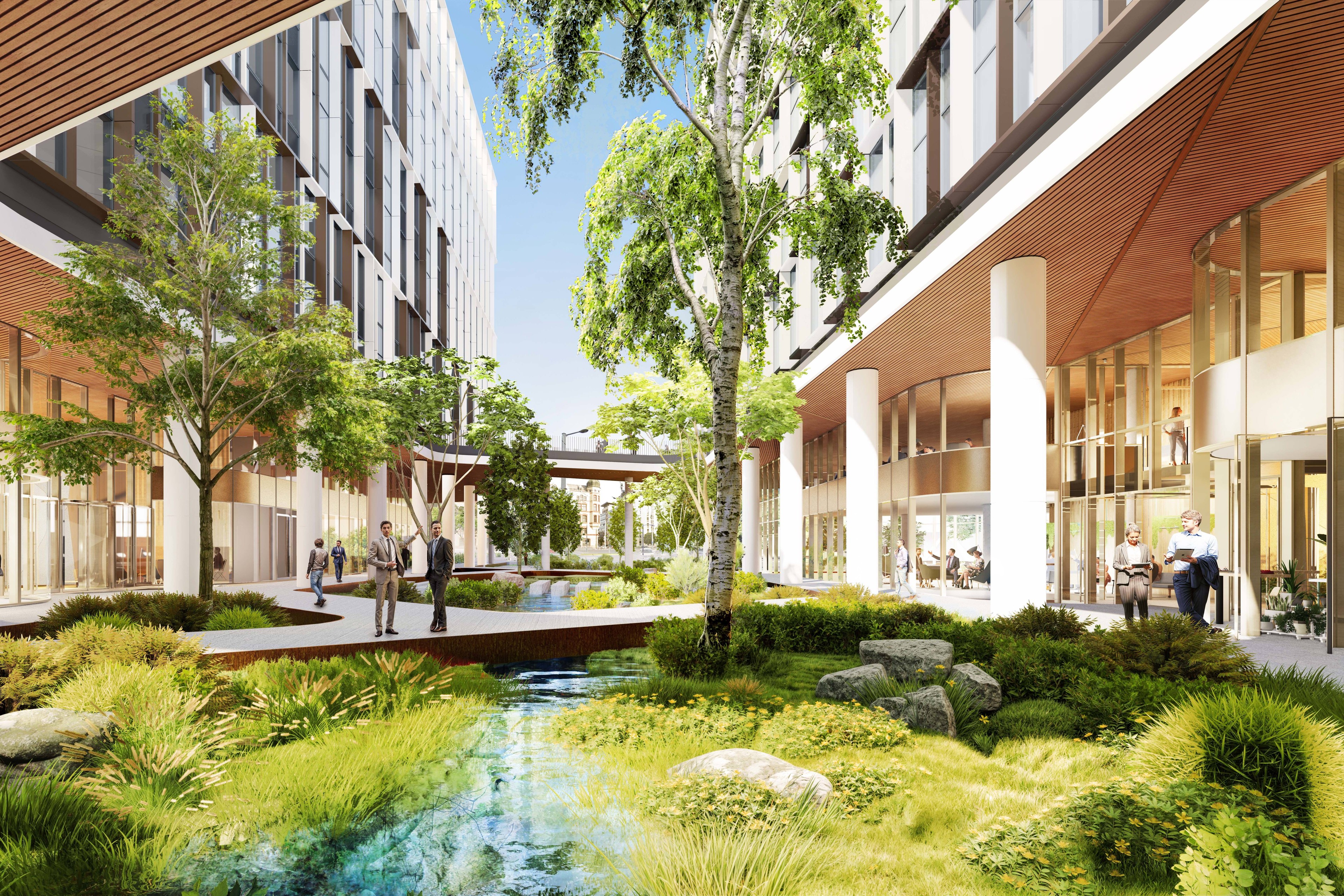 Modern urban park with lush greenery, trees, and people walking near contemporary buildings.