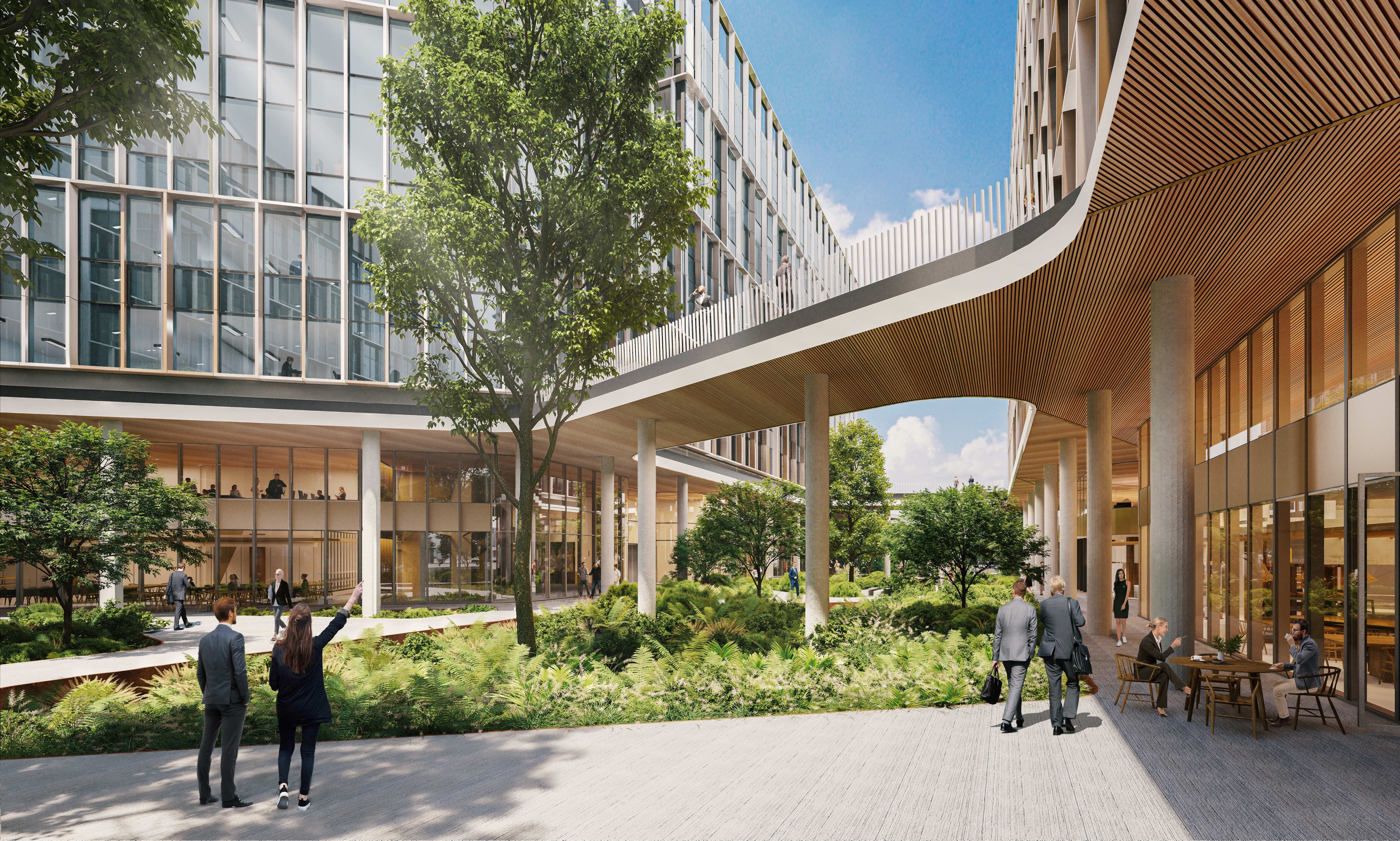 Modern office building with glass facade, surrounded by lush landscaping and pedestrian walkways.