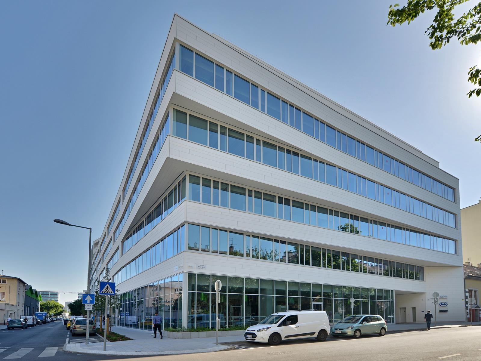 Nordic Light Trio Modern multi-story office building with large windows on a sunny street corner.
