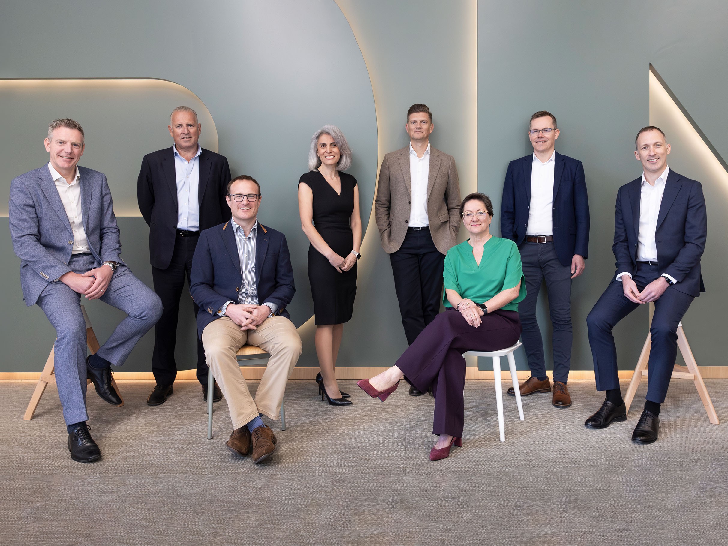 Professional diverse business team posing in modern office setting Group of professionally dressed businesspeople posing in a modern office setting.