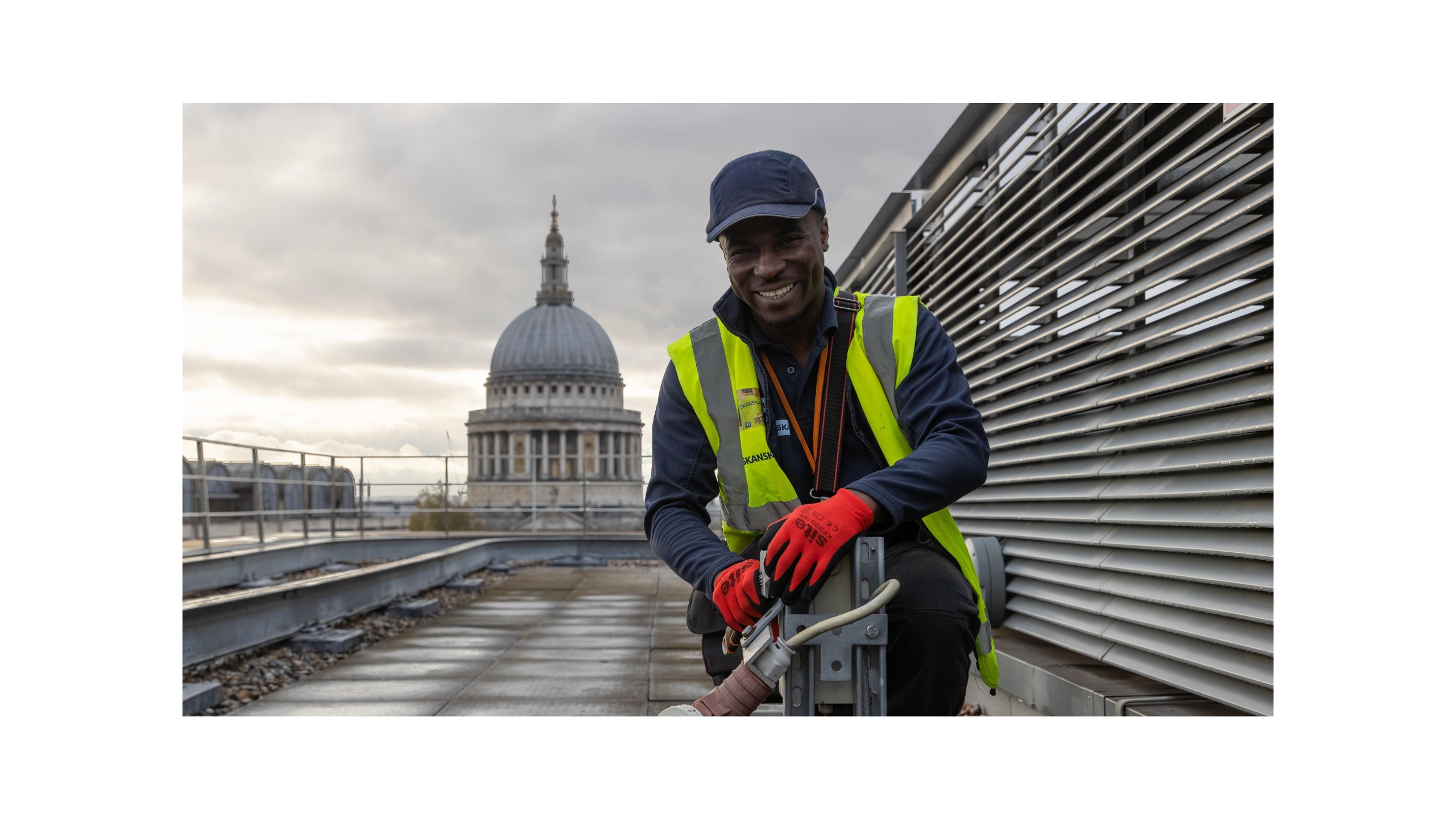 Modern skylight window with clear blue sky view in white room Construction worker in safety gear working on rooftop with St. Paul's Cathedral in background.