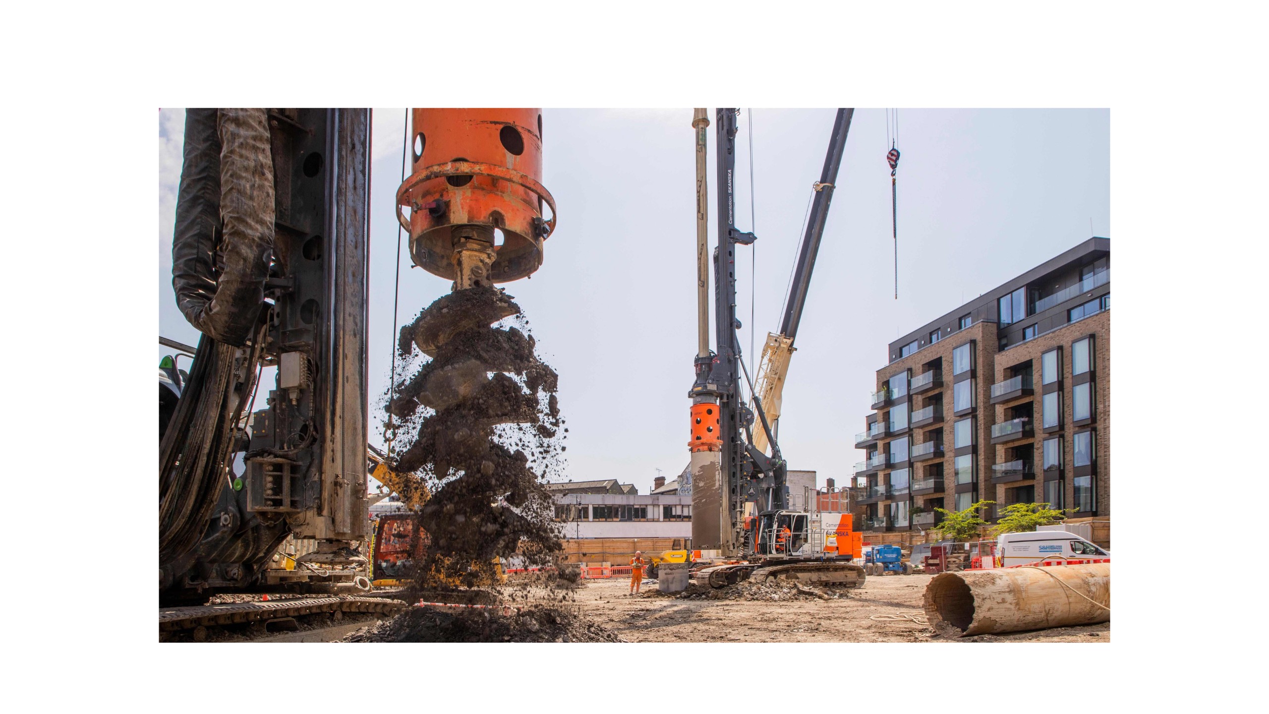 Heavy-duty drilling machinery at urban construction site Construction site with heavy drilling machinery and soil excavation in progress.