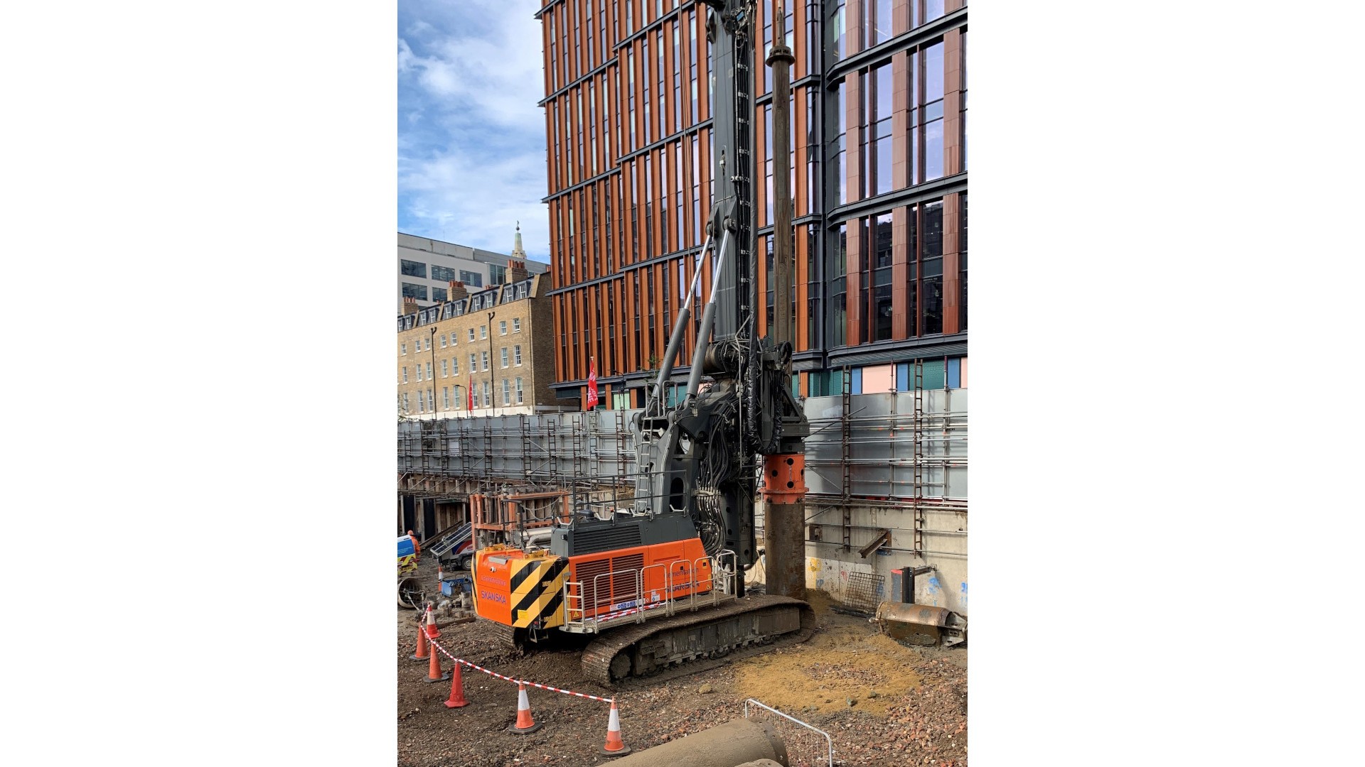 Cementation Skanska piling rig Construction site with a large drilling rig beside a modern building in an urban setting.