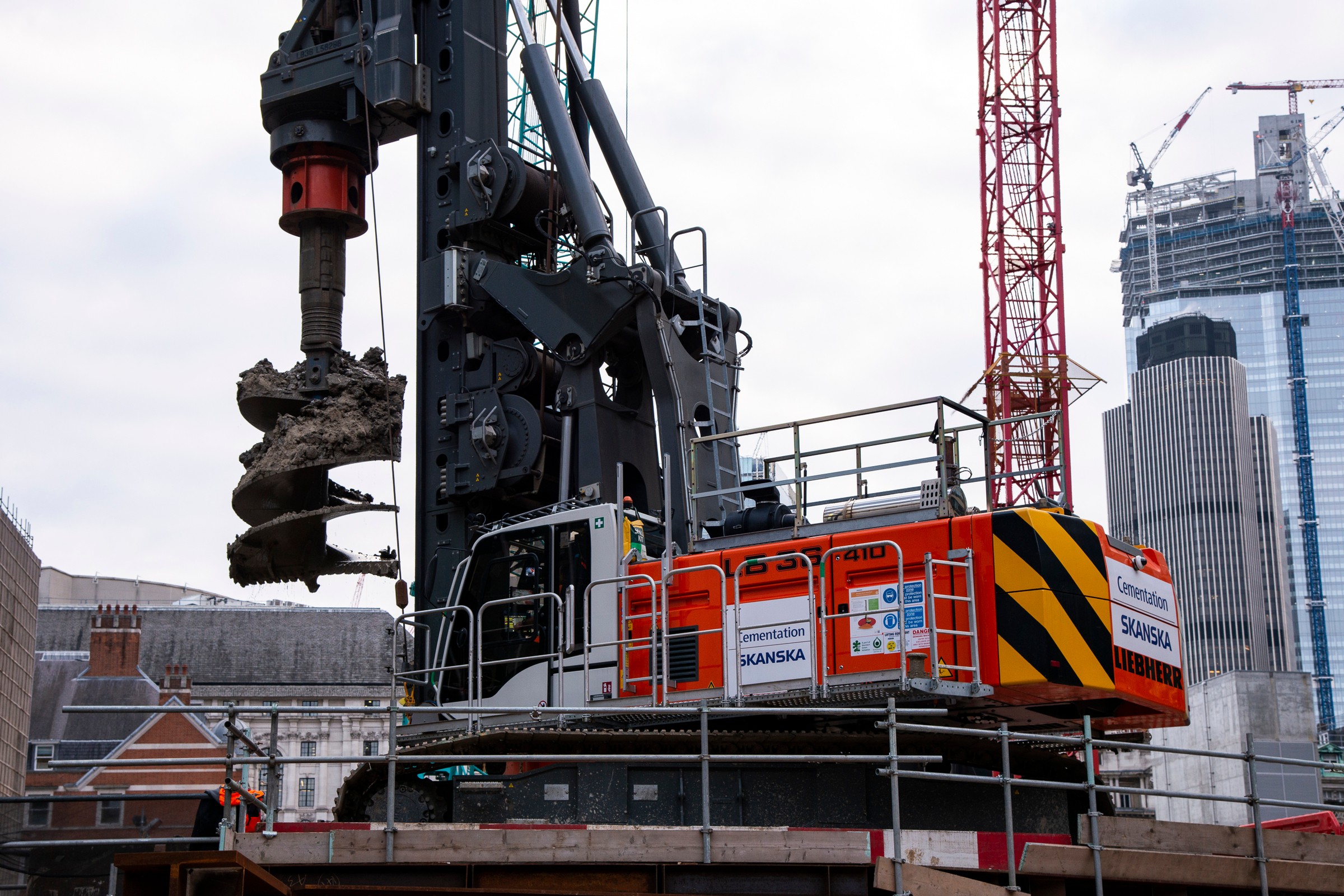 21 Moorfields Large construction drill operated by Skanska at an urban site with skyscrapers in the background.