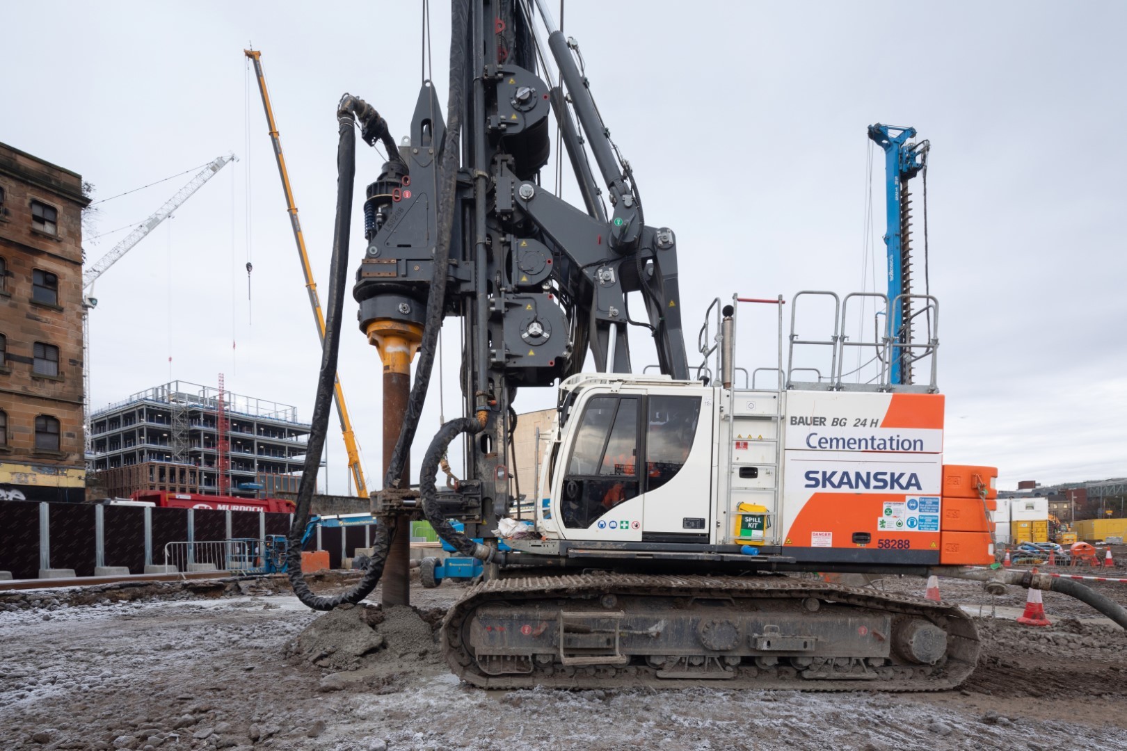 Heavy Duty Construction Drill Rig at Skanska Building Site Construction site with a large drilling rig labeled Skanska, operating in an urban area.