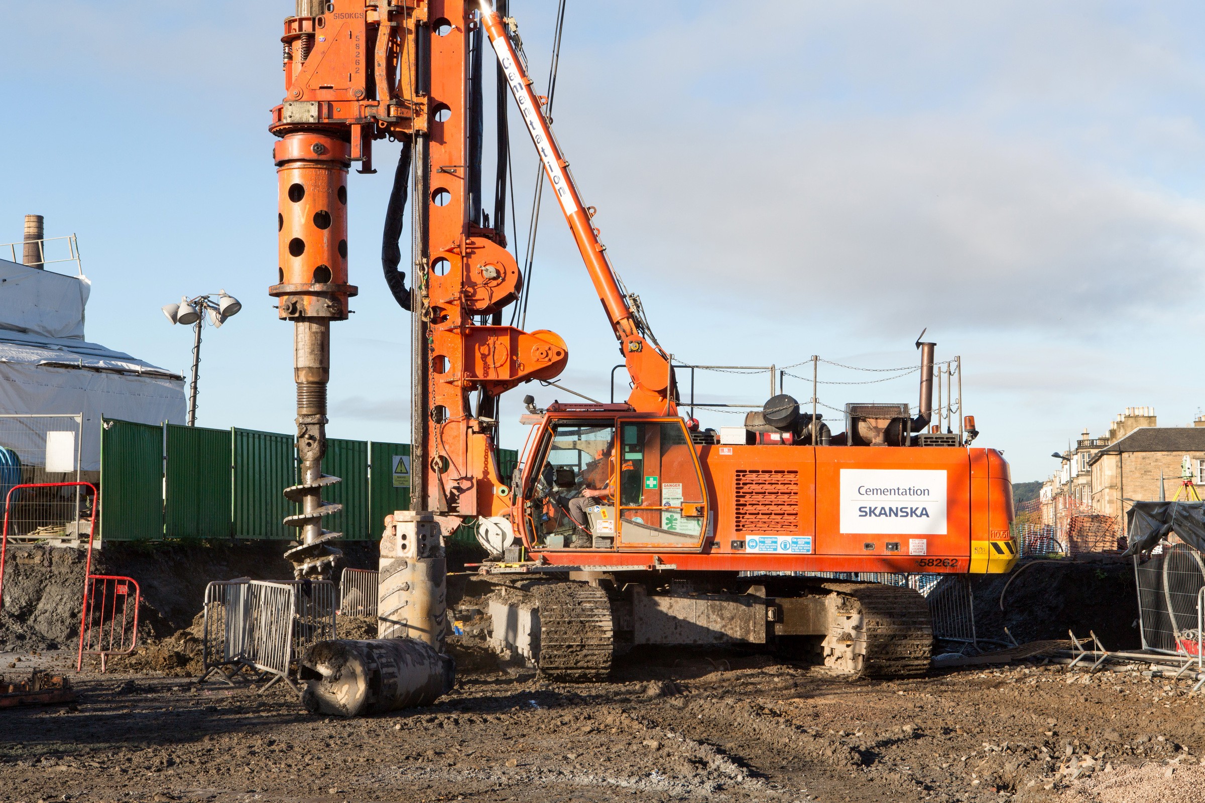 Haymarket Edinburgh Construction site with a large orange drilling rig from Skanska, set against a clear blue sky.