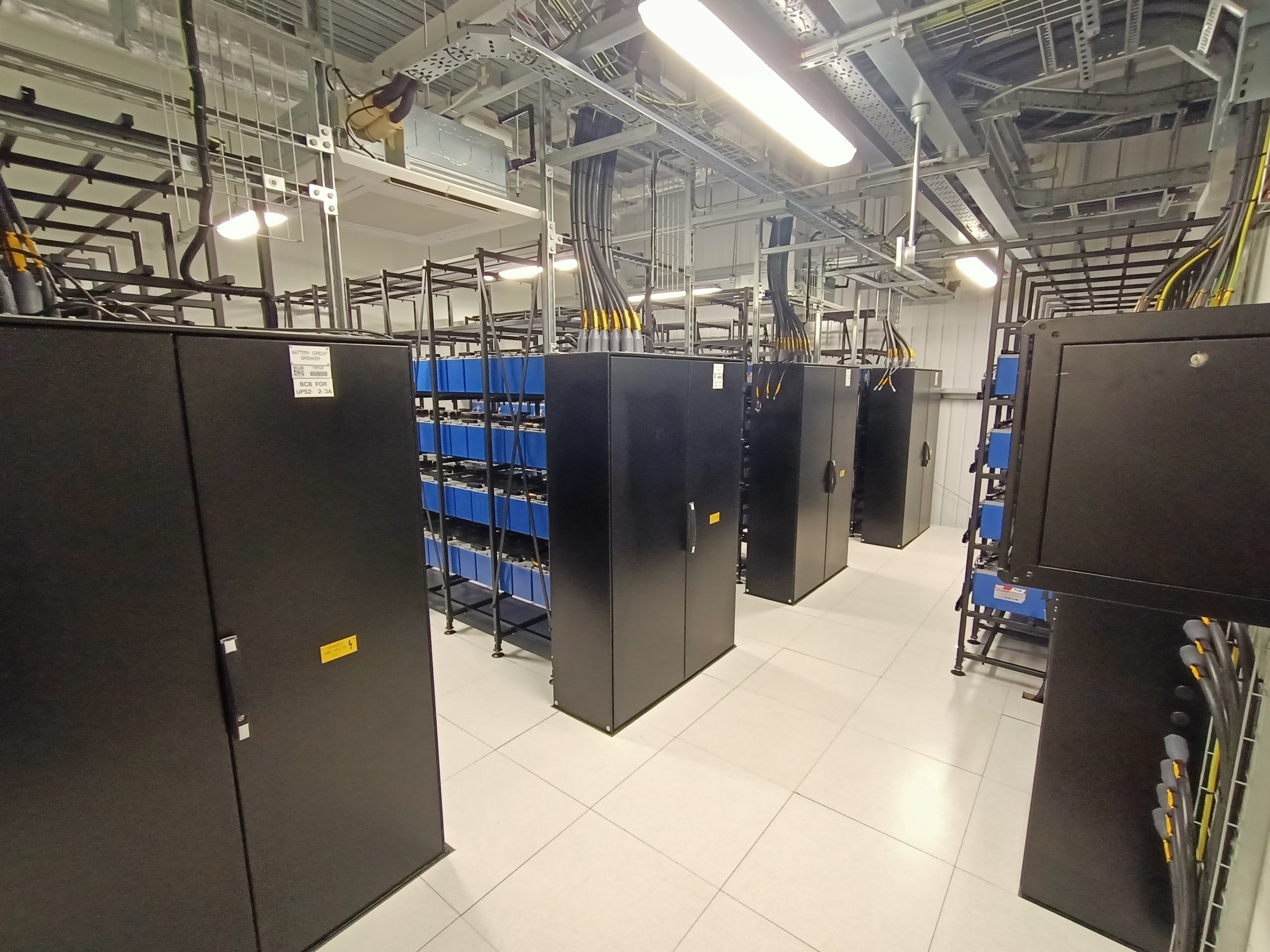 Virtus 11 Data centre room with black server racks and organised cable management under bright lights.