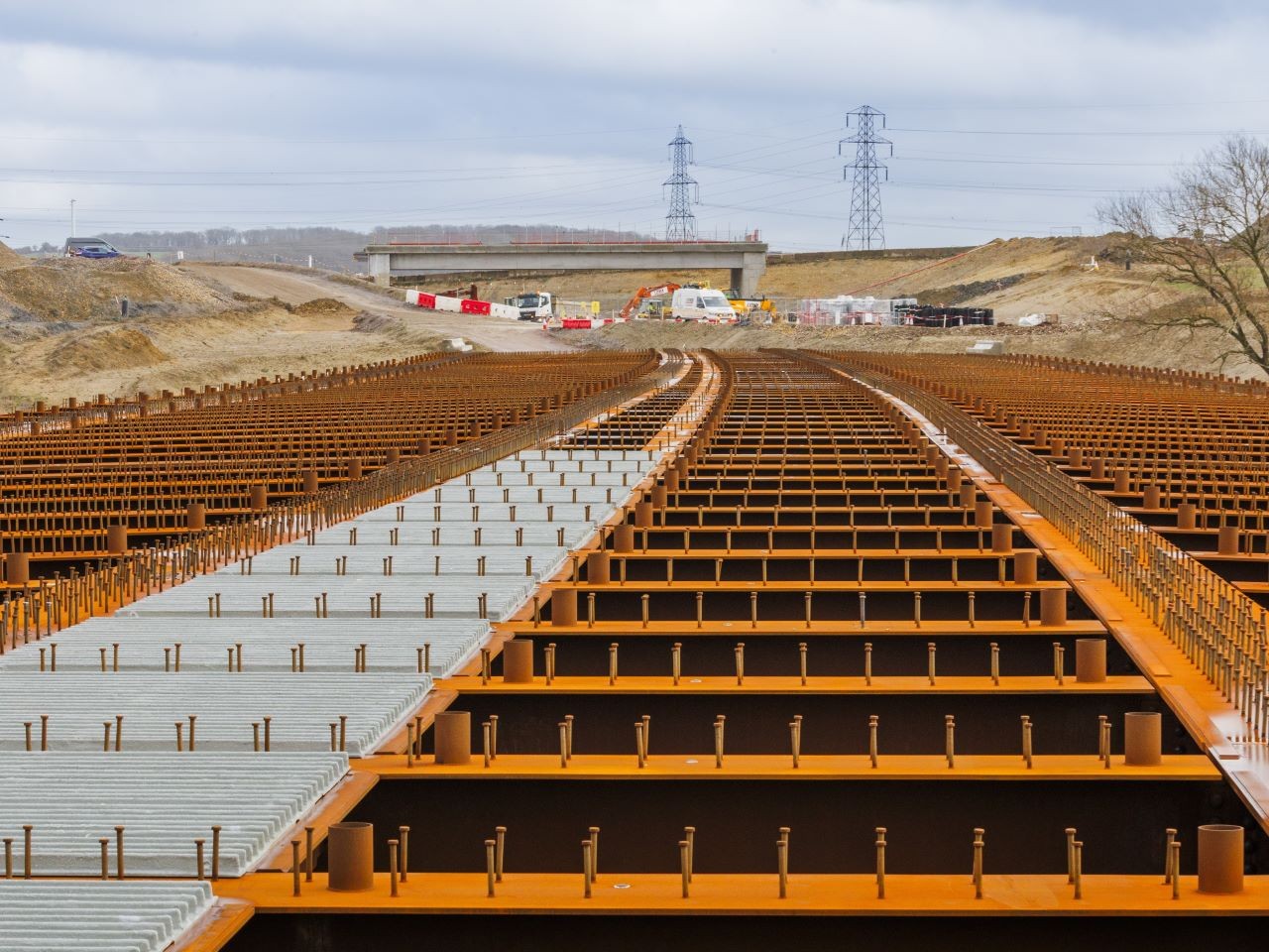 Highway Construction Site Under Cloudy Sky: A Scenic View Construction site with heavy machinery preparing land under a cloudy sky in a rural area.