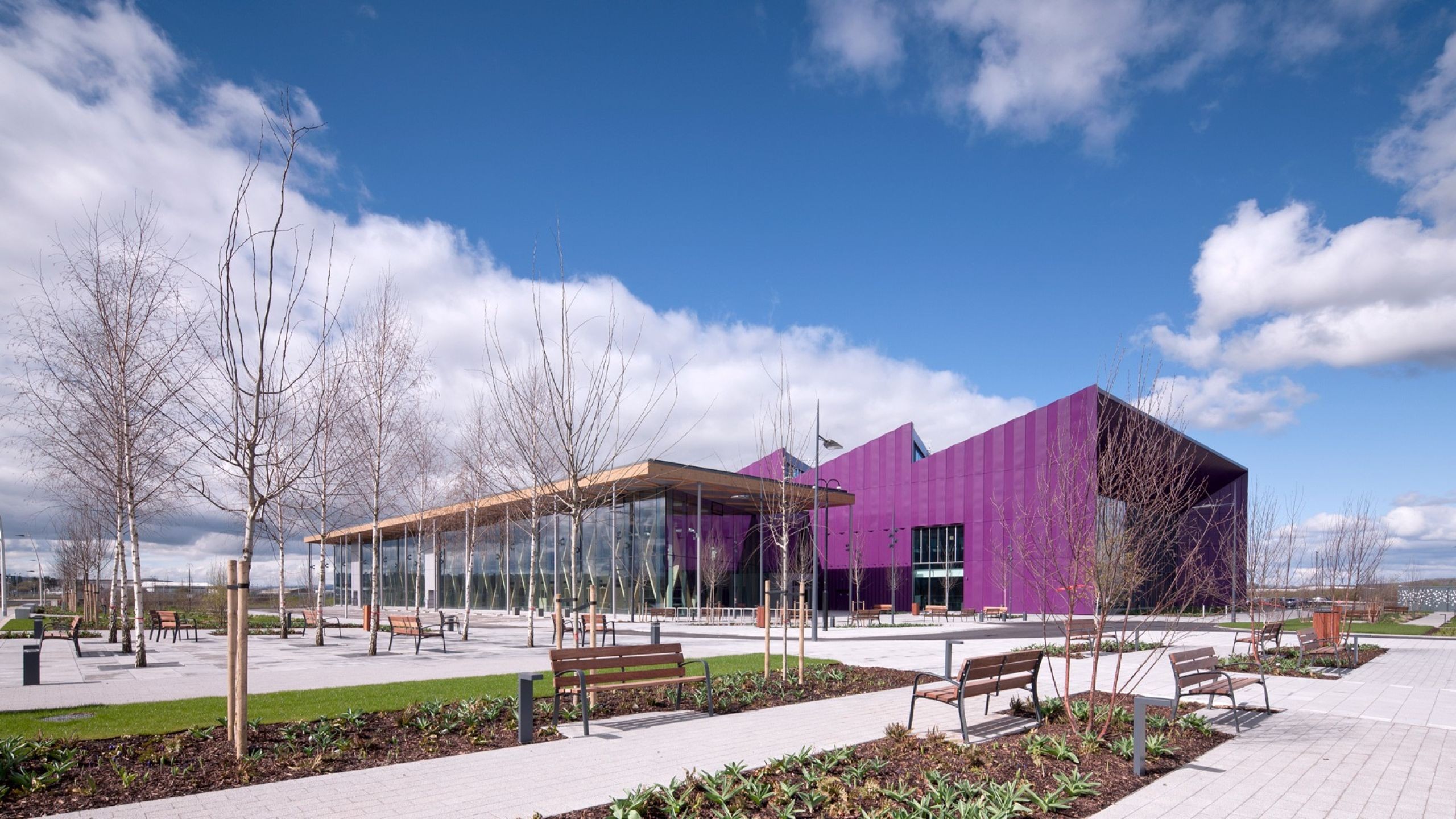 Modern Purple Building with Glass Facade and Outdoor Benches.