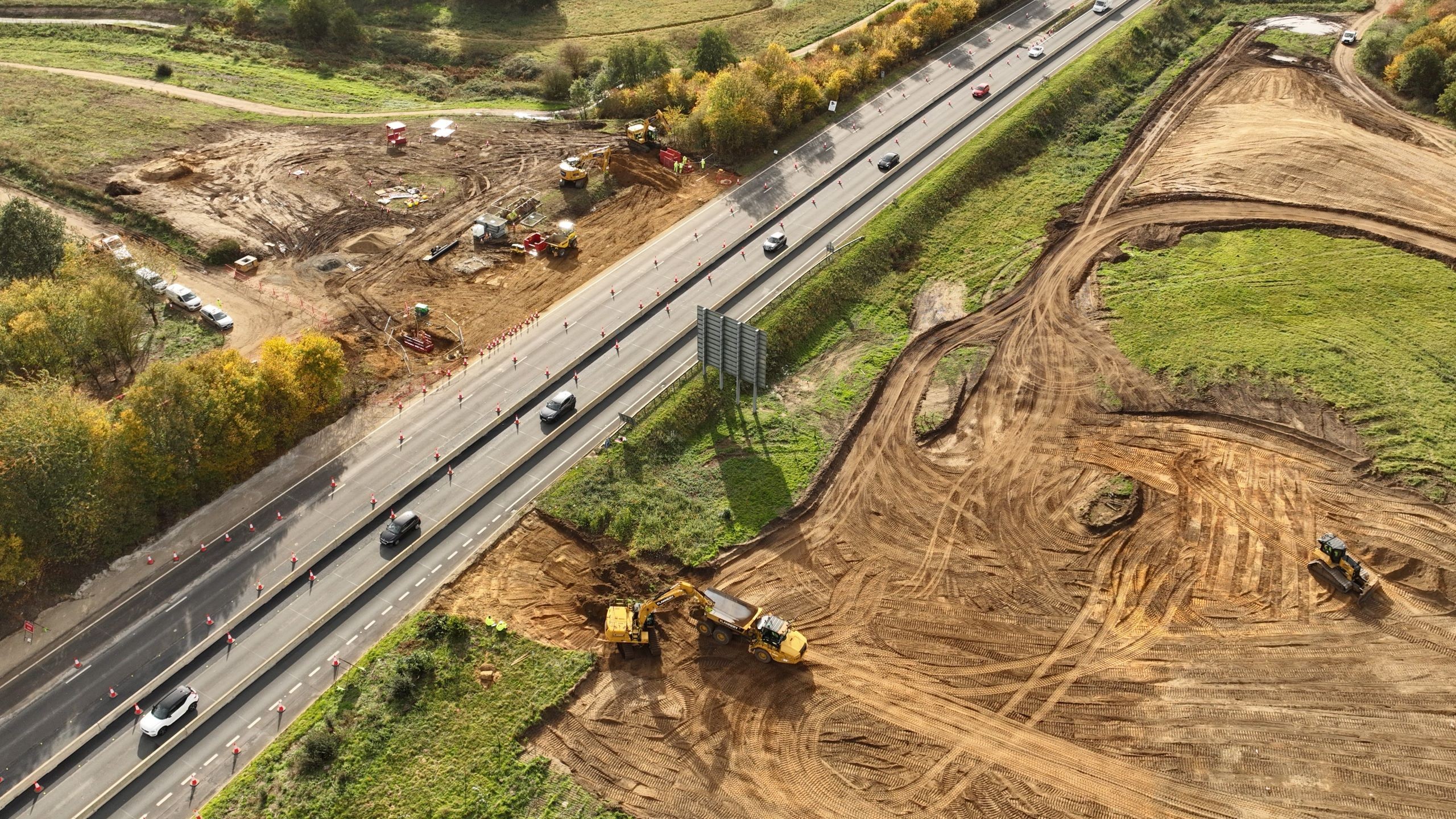Highway Expansion Construction Site with Heavy Machinery Aerial view of highway construction site with heavy machinery and traffic on road.