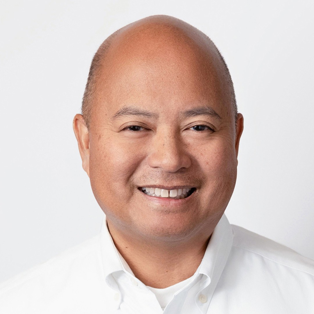 Portrait with White Collared Shirt A person wearing a white collared shirt against a plain light background.