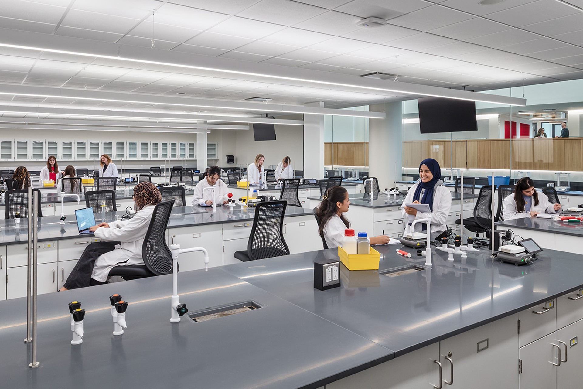 Scientists working in a modern, spacious laboratory with advanced equipment and computers.