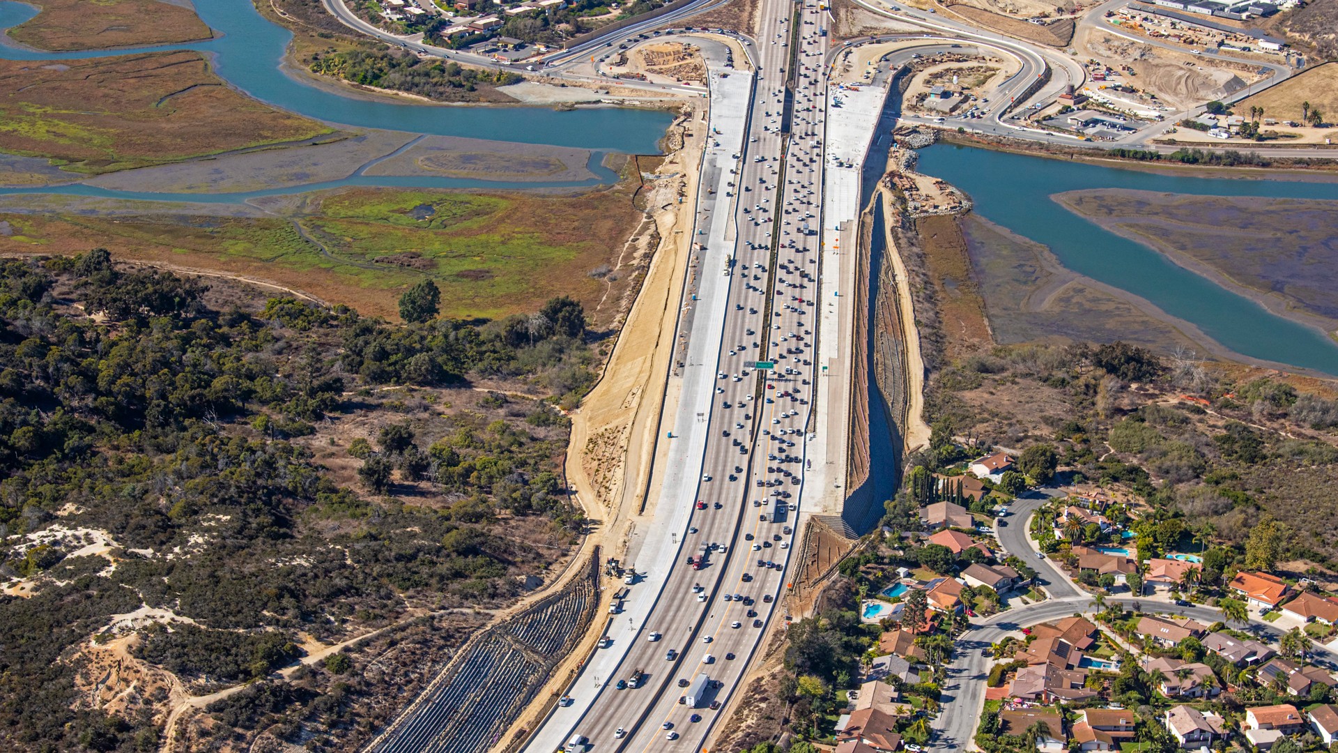Aerial View of Highway and Scenic Landscape Aerial view of a busy highway running through a scenic landscape with rivers and residential areas.