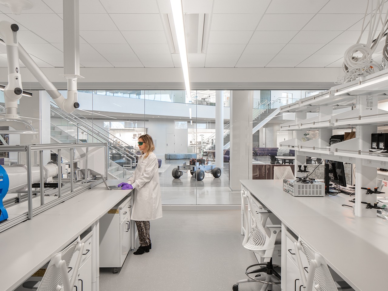 Laboratory with Advanced Equipment and Workspace Laboratory with white workstations, scientific equipment, and a technician in a lab coat.