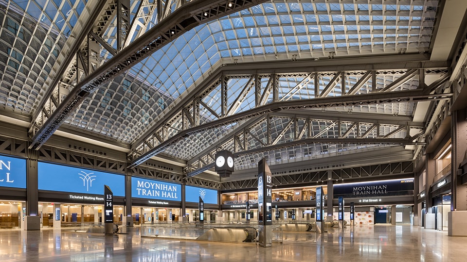 Spacious Moynihan Train Hall interior with glass ceiling and modern architecture.