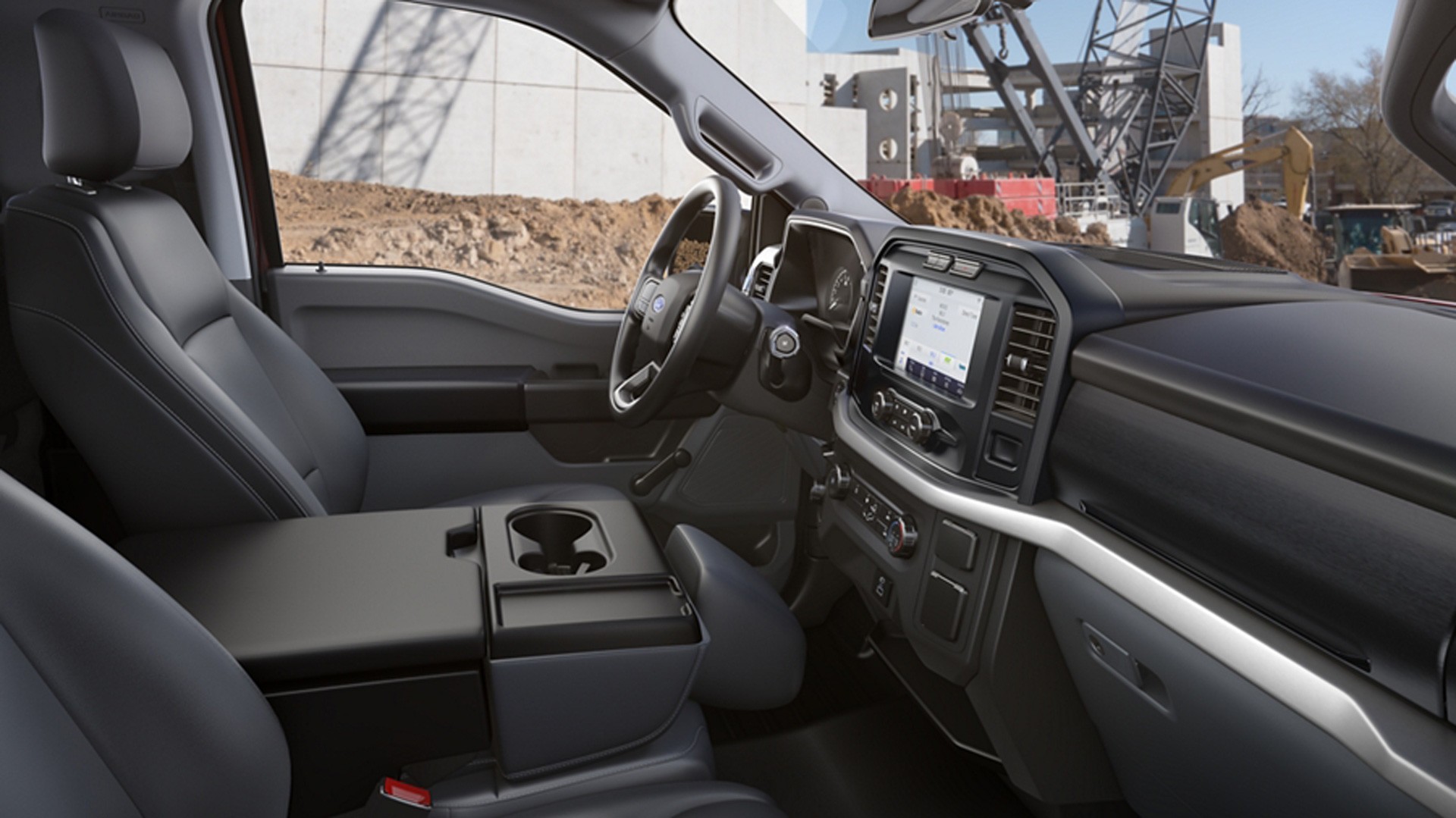 Interior view of a modern black pickup truck cabin with touchscreen dashboard display.