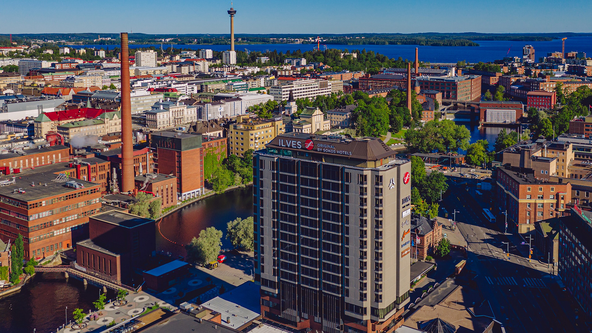 Tammerkosken rannalle vuonna 1986 valmistunut perinteikäs Original Sokos Hotel Ilves uudistui tulevaisuutta varten. Rakenteellisten ja taloteknisten järjestelmien peruskorjauksen yhteydessä myös hotellihuoneet ja ravintola- ja kokoustilat uusittiin. Muodonmuutoksen kruunasi uusi kattoterassi. Ilmakuva Tampereen kaupunkinäkymästä vesiväylien ja viheralueiden kanssa. Keskellä korkea Hotelli Ilves.