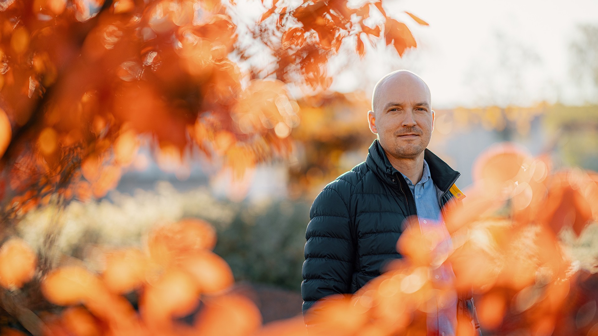 Timo Markkanen on kasvanut skanskalaiseksi monenlaisissa tehtävissä. Mies seisoo ulkona oranssien syyslehtien keskellä aurinkoisena päivänä.