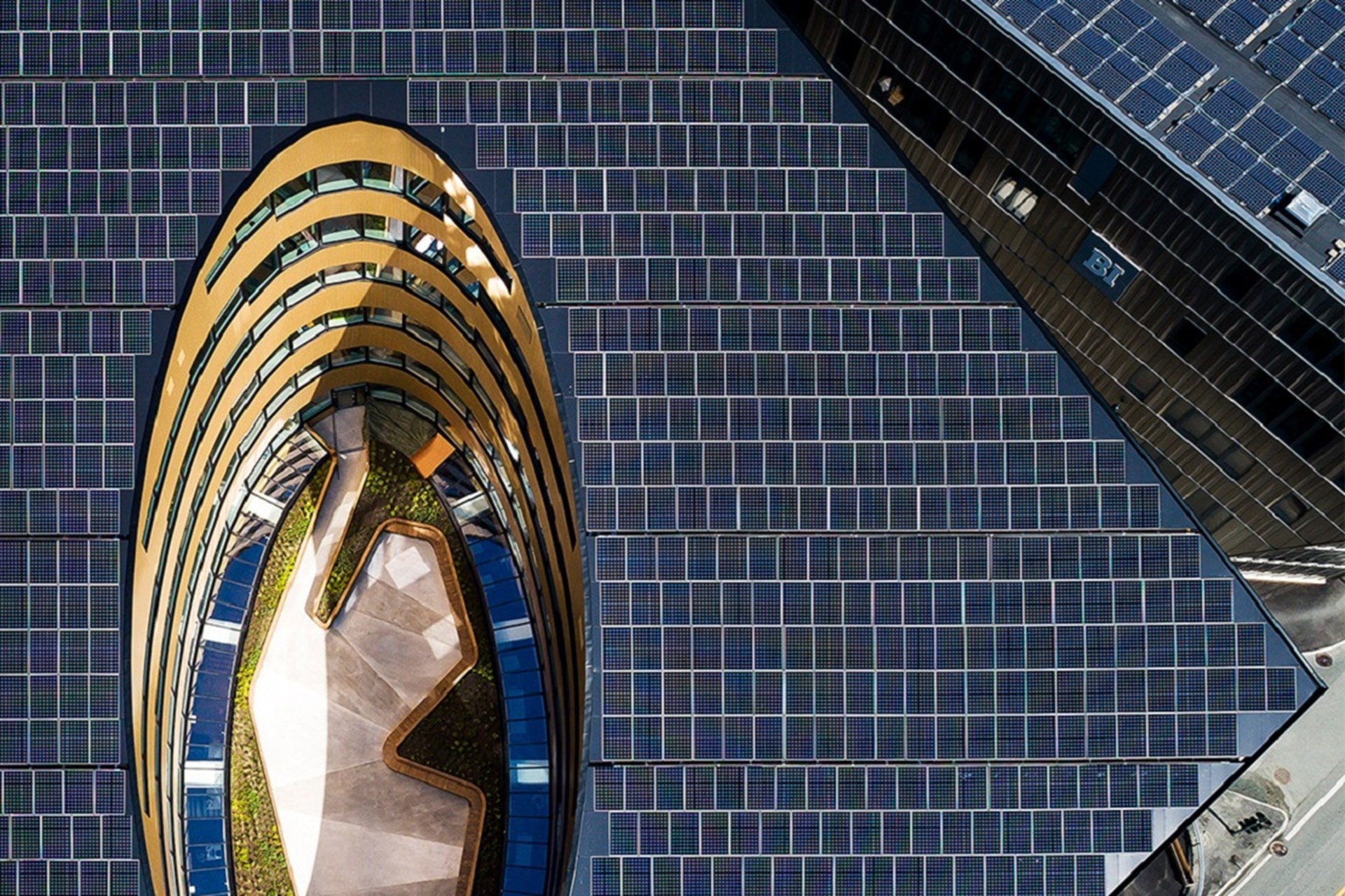 Aerial view of a modern building surrounded by extensive solar panels.