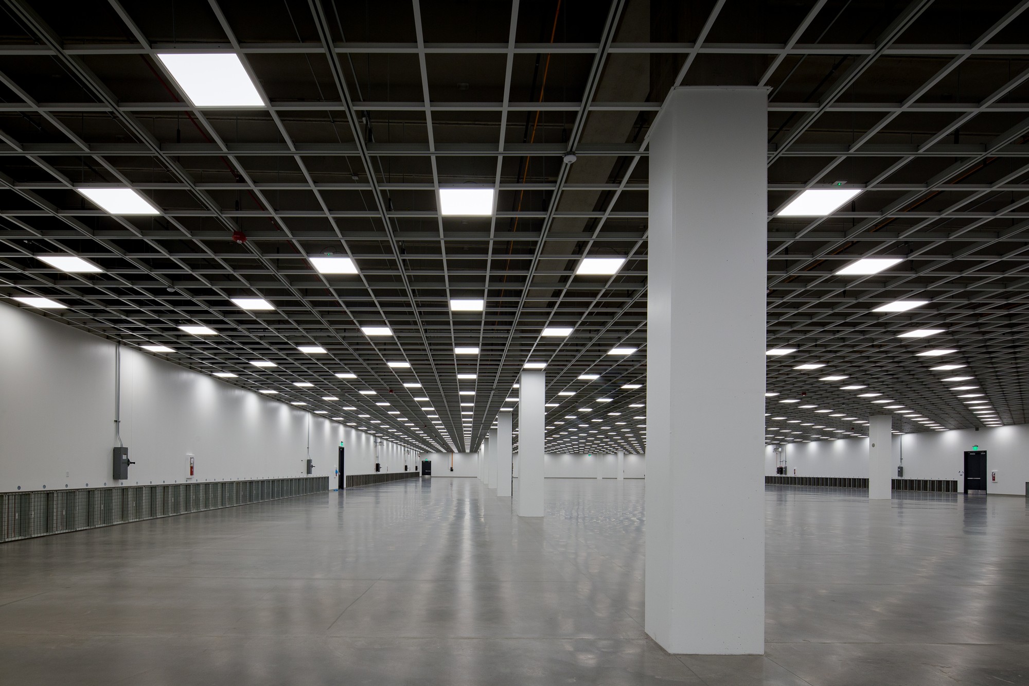 Spacious data center with grid ceiling lights and polished concrete floor.