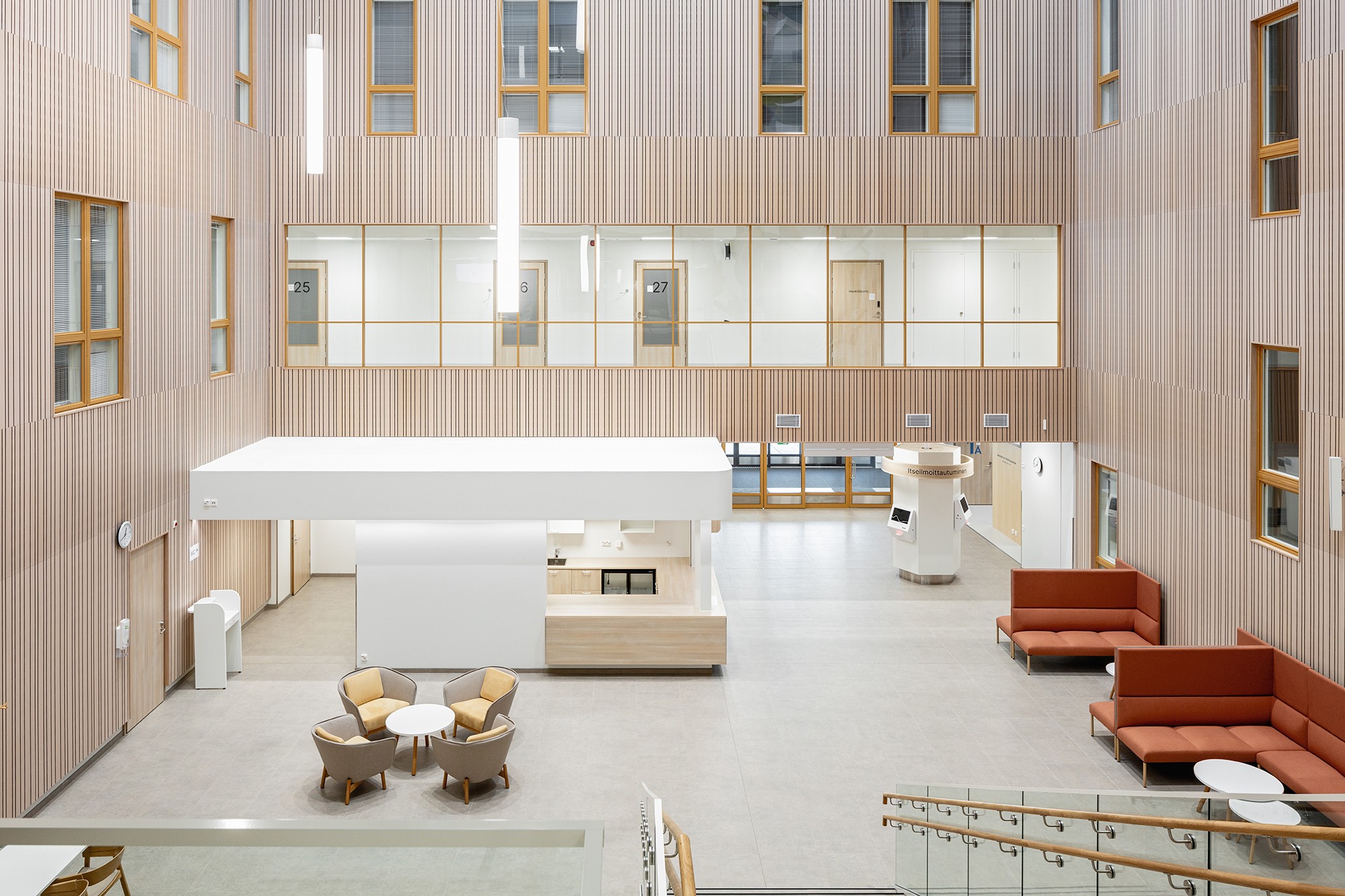 Modern office lobby with wood paneling, seating areas, and large windows for natural light.