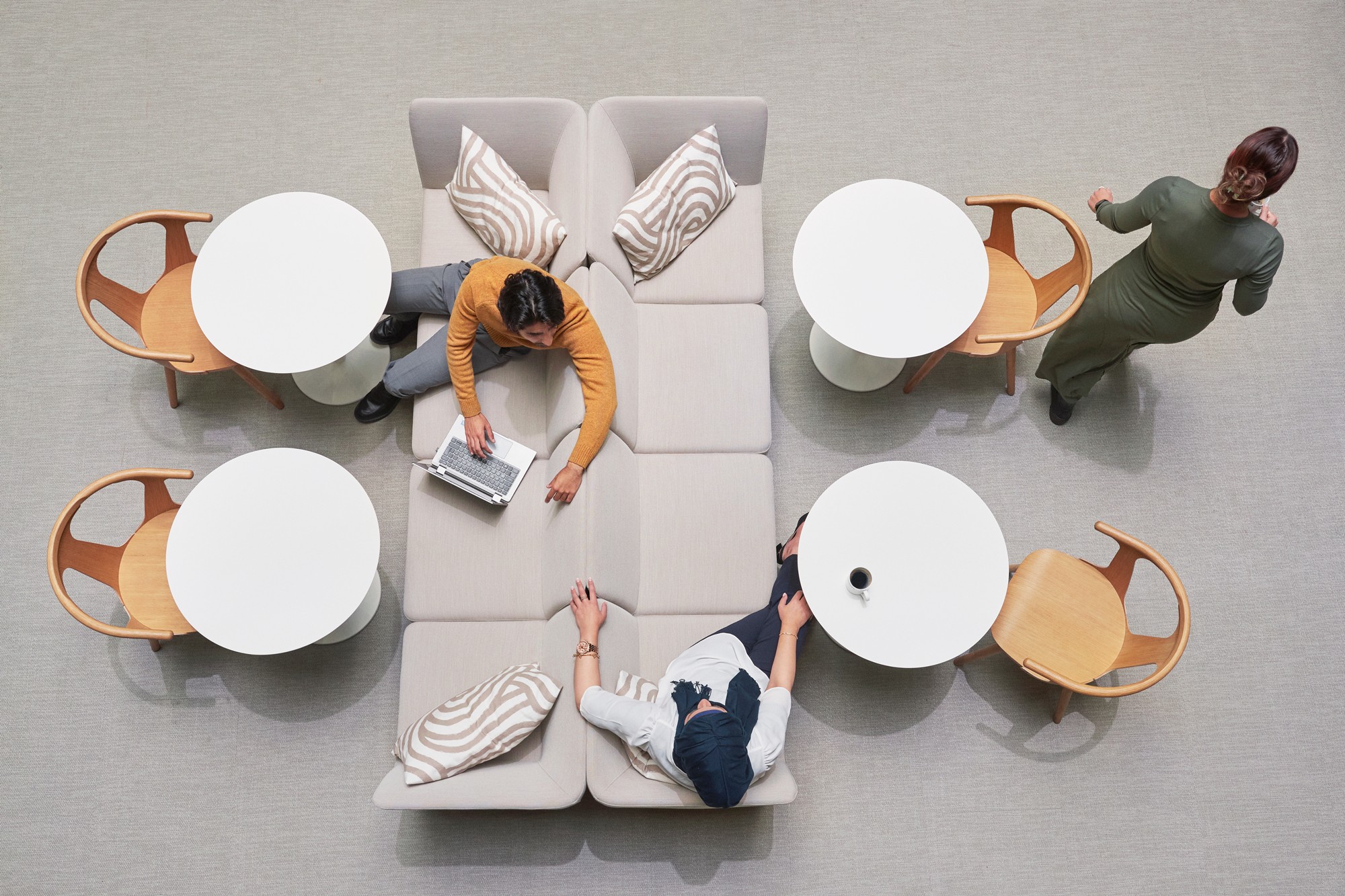 Modern office lounge with people and round tables.